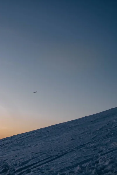 drone gün batımı arka planda kar kaplı tepeler üzerinde uçan 