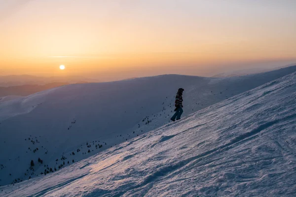 gün batımı sırasında karlı tepenin üzerinde duran kar yatılı silüeti