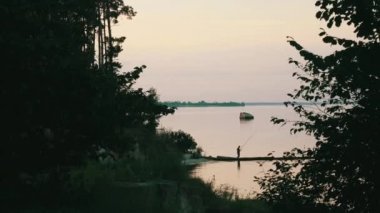 deniz arka planda balıkçı silüeti  