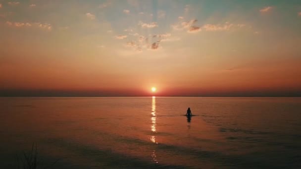 日落时在水中行走的妇女 — 图库视频影像