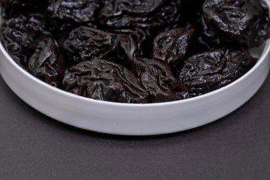 Gri arkaplanda servis edilen çukur kuru erik