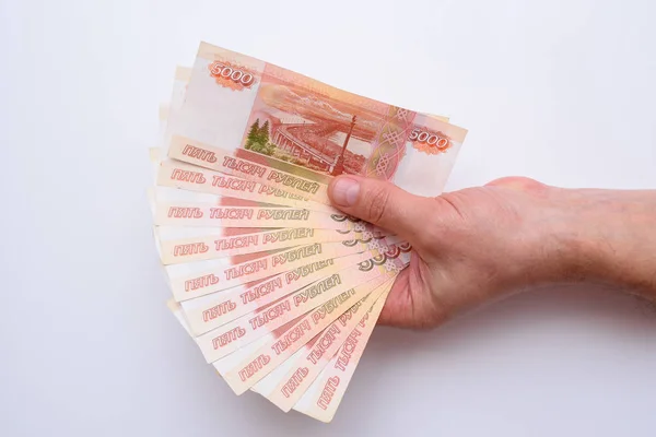 Beyaz arka plan üzerinde izole elinde beş bin Rus ruble. Bohça-in banknot 5000 ruble, Rusya Federasyonu.