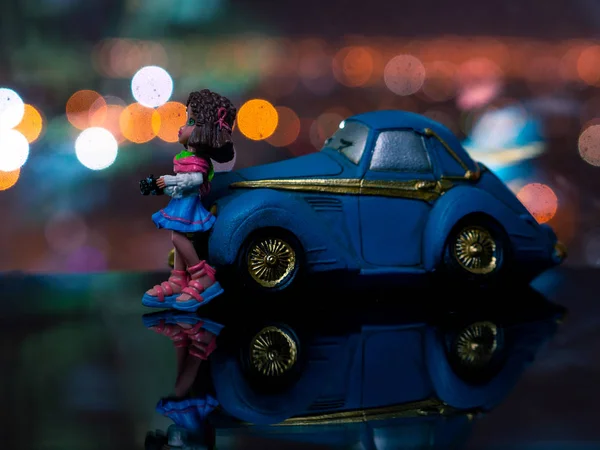 밤에 파란색 차에 서 서 장난감 여자. — 스톡 사진