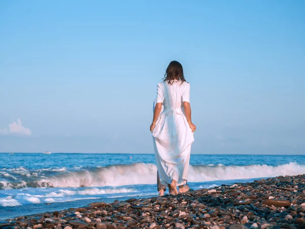 Birbirine aşık bir çift kumsalda beyaz elbiseler içinde koşuyor..