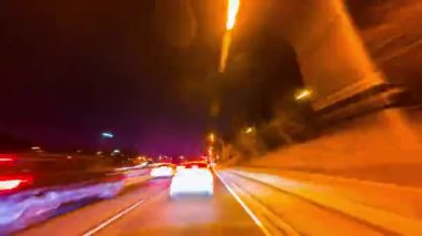 Toronto, Ontario, Kanada 'da sürat sürüşünün yüksek hızına uzun süre maruz kalma. Otobanda hızlı araba manzarası ve bir sürü trafik ışığı var. Şehir merkezindeki binaların yanından geçiyoruz.
