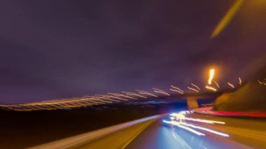 Şehir merkezindeki caddelerden ve yollardan geçen aydınlık metropolde gece arabası. Uzun süreli çekim zamanı ya da gece şehir yollarında hareket eden aracın yüksek sürati. Otobanda zaman aşımı.