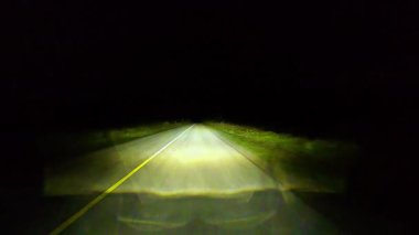 Kır evindeki asfalt yolda gece sürüşü sadece farlarla karanlık bir gece manzarası. Seyahat ederken kırsal şeritte ilerlemek. Manitoulin Adası, Ontario, Kanada 'da asfalt yoldan ilerliyoruz..