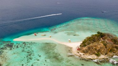 Beyaz kumlu sahili olan küçük torpik bir ada..