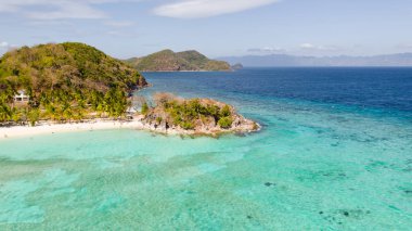 Beyaz bir plaja sahip lagün. Turistler plajda dinlenmek.