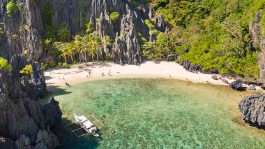 Kayalıklarla çevrili güzel bir lagün. Kayalıklarla çevrili küçük bir gizli tropikal lagün içinde yüzücülerin havadan drone görünümü