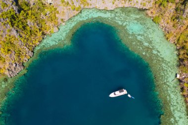 Masmavi lagün tekne. Kayalıklarla çevrili turkuaz sulu lagün.