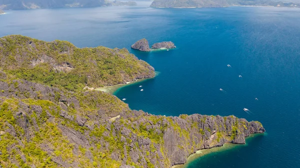 Klippiga kusten med en vit strand. Tropisk ö med djungel. — Stockfoto