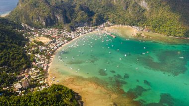 El Nido kasabası, yukarıdan bakın. Tekneler ve kayalıklarla çevrili sahil kasabası ile turkuaz lagün.