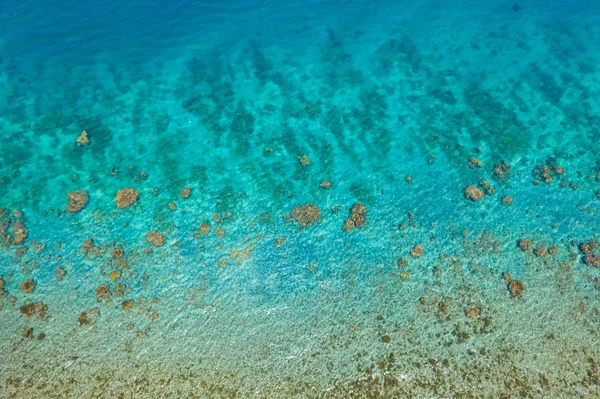 Sakin deniz suyunun havadan görünüşü. Kıyıya yakın temiz bir okyanus suyunun üst görüntüsü.. — Stok fotoğraf