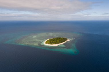 Masmavi su ve mercan resifleri ile çevrili küçük bir ada, üst görünümü.