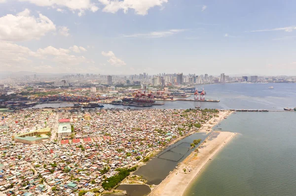 Puerto en Manila, Filipinas. Puerto marítimo con grúas de carga. Paisaje urbano con áreas pobres y centro de negocios en la distancia, vista desde arriba . — Foto de Stock