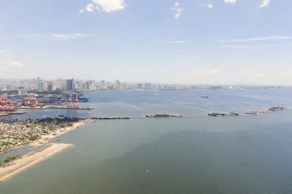 Port in Manila, Philippines. Sea port with cargo cranes. Cityscape with poor areas and business center in the distance, view from above. — Stock Photo, Image