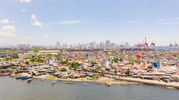 The urban landscape of Manila, with slums and skyscrapers. Sea port and residential areas. The contrast of poor and rich areas.