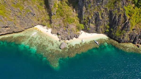 Klippiga kusten med en vit strand. Tropisk ö med djungel. — Stockfoto