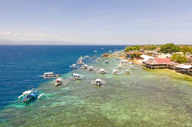 Cebu adasının sahili, Moalboal, Filipinler, en iyi manzara. Güneşli havalarda kıyıya yakın tekneler.
