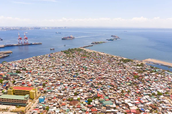 Porto em Manila, Filipinas. Porto marítimo com guindastes de carga. Cityscape com áreas pobres e centro de negócios à distância, vista de cima . — Fotografia de Stock