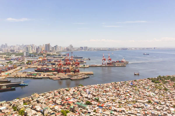 Puerto en Manila, Filipinas. Puerto marítimo con grúas de carga. Paisaje urbano con áreas pobres y centro de negocios en la distancia, vista desde arriba . — Foto de Stock