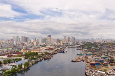 The urban landscape of Manila, with slums and skyscrapers. Sea port and residential areas. The contrast of poor and rich areas. clipart