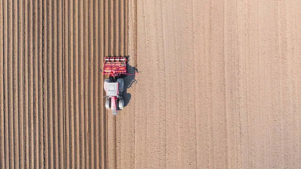 Traktör sürülmüş bir alanda, üst görünümde. Sebze dikimi için tarım alanı.