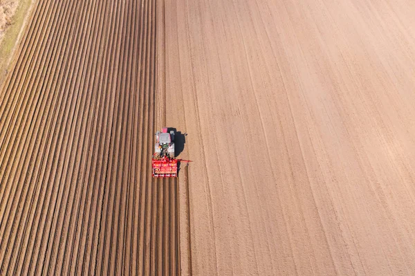 Tarım arazisinde disk harrows ile Traktör, üst görünümü. Traktör sürülmüş bir tarlada kırışıklıkları keser. Traktör ile tarımsal çalışmalar.