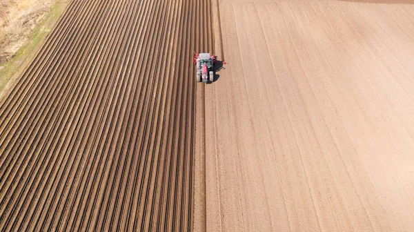Traktör sürülmüş bir alanda, üst görünümde. Sebze dikimi için tarım alanı.