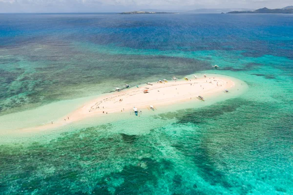 İnsanlar tropik bir adada dinlenebilir ve lagünde yüzerler. Çıplak Ada, Siargao. Beyaz adaya teknelerle turistler geldi.
