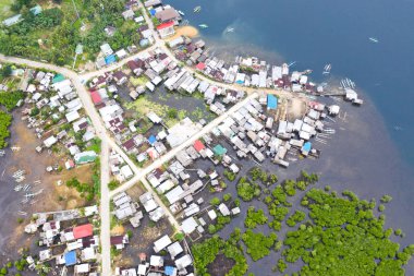 Beton yol ve mangrovlarda bir köy, üst görünümü.