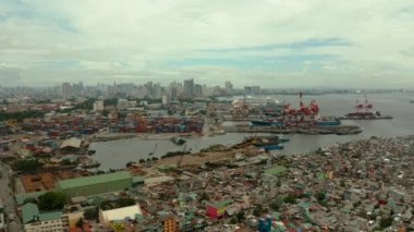 Liman Manila, Filipinler. Kargo vinçleri ile deniz limanı. Uzaklıkta yoksul bölgelere ve iş merkezine sahip Cityscape, yukarıdan görünümü.