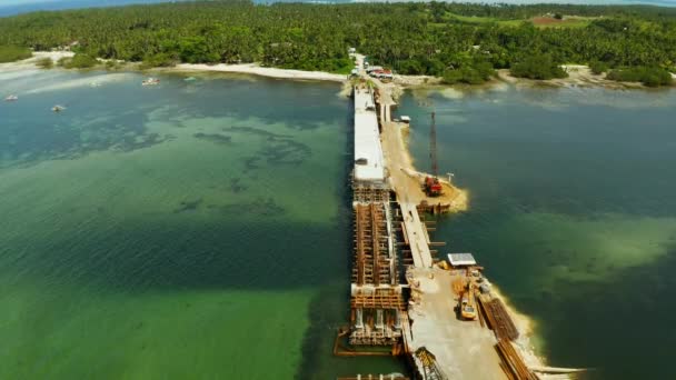 Construcción de un puente sobre la bahía. Equipo de construcción en el puente, vista superior. Siargao, Filipinas . — Vídeo de stock