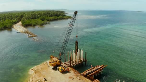 Construção de uma ponte sobre a baía. Equipamento de construção na ponte, vista superior. Siargao, Filipinas . — Vídeo de Stock