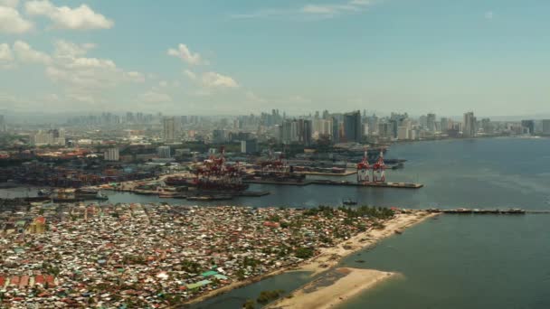 Port w Manili, Filipiny. Port morski z żurawi cargo. Cityscape z biednych obszarów i centrum biznesowego w oddali, widok z góry. — Wideo stockowe