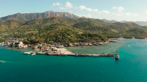 Egy kis tengeri kikötő a város Coron, Fülöp-szigetek. teherhajó és csónak a mólón. — Stock videók