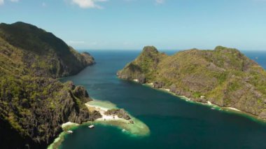 Beyaz sahili olan kayalık sahil. Ormanlı tropik bir ada. Tropikal deniz suyu lagünü ve plajı, Filipinler, El Nido.