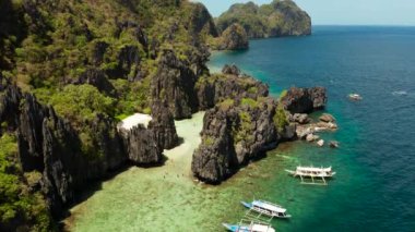 Tropikal deniz suyu lagün ve plaj, Filipinler, El Nido. Kayalık kıyı ve beyaz plaj ile tropikal ada. Tekne ile turistik rotalar.