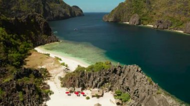 Tropikal deniz suyu lagün ve plaj, Filipinler, El Nido. Kayalık kıyı ve beyaz plaj ile tropikal ada. Tekne ile turistik rotalar.