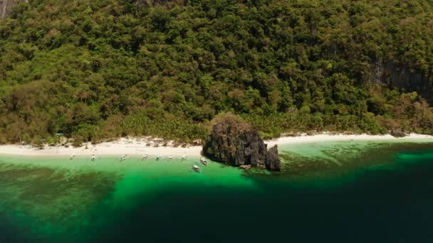 Isla tropical con playa de arena. El nido, Filipinas. La costa de una isla tropical con una playa blanca y arrecifes de coral . — Vídeo de stock