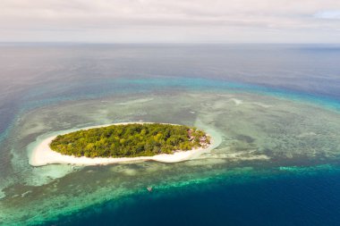 Masmavi su ve mercan resifleri ile çevrili küçük bir ada, üst görünümü.