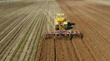 Tarım arazisinde disk harrows ile Traktör, üst görünümü. Traktör sürülmüş bir tarlada kırışıklıkları keser. Traktör ile tarımsal çalışmalar.