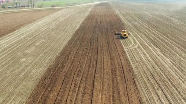 Machines agricoles pour le traitement du sol sur le terrain. Le tracteur laboure le sol, et une vue de dessus . — Video