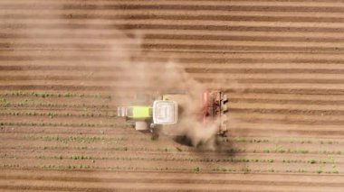 Arazideki toprağı işlemek için tarım makineleri. Traktör toprağı sürüyor, ve bir üst manzara..