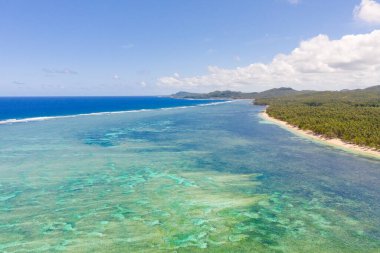 Deniz Burnu, Siargao, Filipinler adasının kıyısında. Dalgalı mavi deniz ve büyük bulutlu gökyüzü.