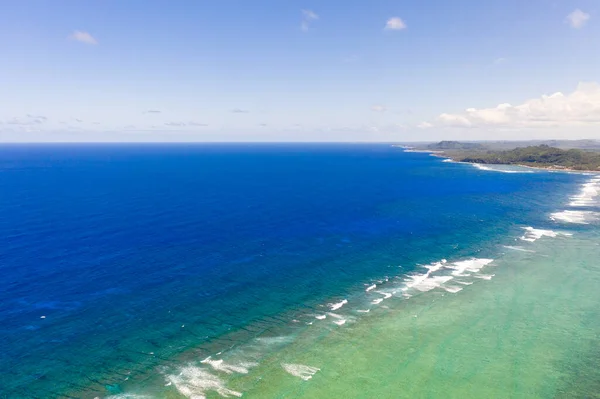 Seascape, costa da ilha de Siargao, Filipinas. Mar azul com ondas e céu com grandes nuvens. — Fotografia de Stock