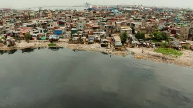 Manila 'nın varoşlarında limana yakın. Fakir insanların evleri. Çöplerin okyanusa dökülmesi.