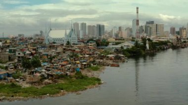 Büyük bir şehrin arka planında fakir insanların gecekondu mahalleleri. Manila şehri, yoksul ve yoksul bölgeler.