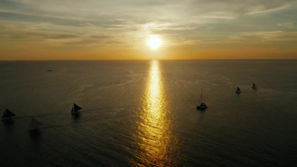 Barcos à vela no mar ao pôr-do-sol na ilha de Boracay, Filipinas. Veleiro contra um belo pôr do sol . — Vídeo de Stock